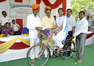निशुल्क साइकिल वितरण योजना के तहत ब्यावर में शिक्षा राज्य मंत्राी श्री वासुदेव देवनानी, विधायक शंकर सिंह रावत के संग एक बालिका को मंच पर साइकिल प्रदान करते हुए।
