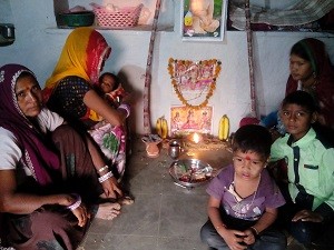 घर मे लक्ष्मी पूजा अर्चना करते ग्रामिण। 