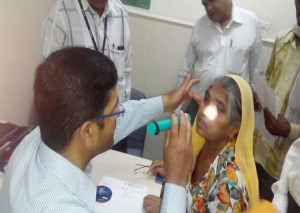 नि:शुल्क कृत्रिम नेत्र लेेैंस प्रत्यारोपण शिविर में महिला नेत्र रोगी का नेत्र परीक्षण करते डॉ. विनीत चंडक।
