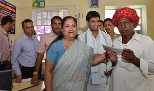 मुख्यमंत्री श्रीमती वसुन्धरा राजे ग्राम पंचायत जयसिंह पुरा में भौरी लाल को रूपे कार्ड देते हुए