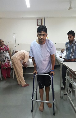 मित्तल हॉस्पिटल में उपचार लाभ ले रहे कूल्हा प्रत्यारोपण कराने वाले युवक प्रशांत शर्मा वॉकर पर चलते हुए।
