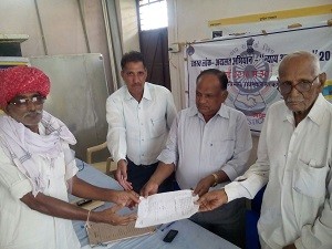 उपखण्ड अधिकारी श्री जगदीश नारायण बैरवा शिविर में प्रार्थी बैजनाथ व किशनलाल जाट को राजस्व रिकार्ड जमाबंदी की प्रति सौंपते हुए