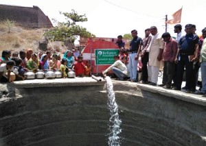 Reliance Foundation tankers pouring water in a community well in Thergao...