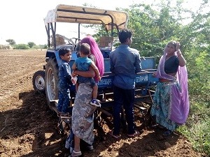 सूरजपुरा क्षेत्र मे खेत पर टेक्टर से फसल की बुवाई करते काष्तकार परिवार।फोटो-षंकर खारोल