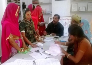 वित्तीय समावेश दिवस में आवेदन करती महिला श्रमिक