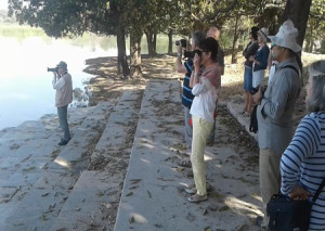 ठंड तालाब में पक्षी को निहारते हुए विदेशी सेलानी