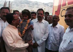प्रो. वासुदेव देवनानी अजमेर जिले के बोराज गांव में ग्रामीण बालिका को राजकीय स्कूल में प्रवेश दिलाकर स्नेह पूर्वक गोद में लेकर नाम पूछते हुए।