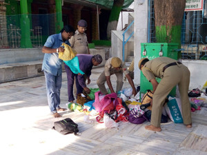 पुलिस कर्मी छानबीन करते हुए