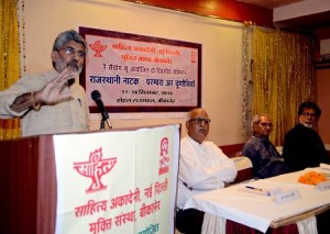 साहित्यकार अर्जुन देव चारण संबोधन दे रहे हैं। मंच पर हैं राजेंद्र जोशी; लक्ष्मीनारायण रंगा और शांतनु जी।